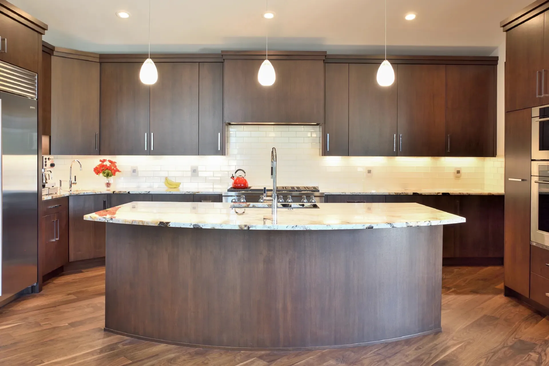 Custom kitchen with curved island by Millcreek Cabinet and Design